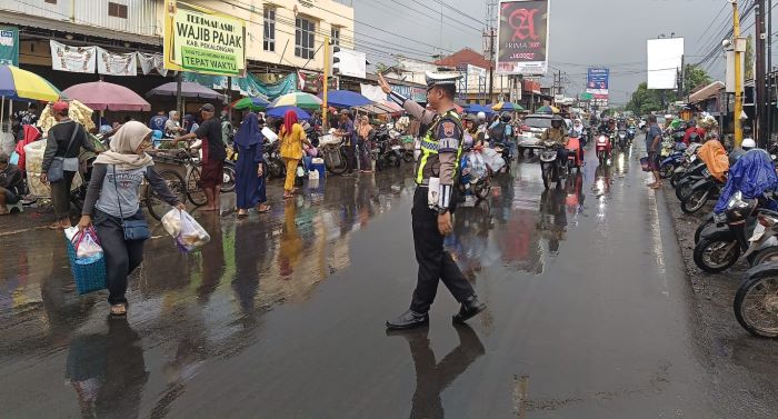 Diguyur Hujan Deras, Personel Polres Pekalongan Tetap Atur Lalu Lintas di Pagi Hari