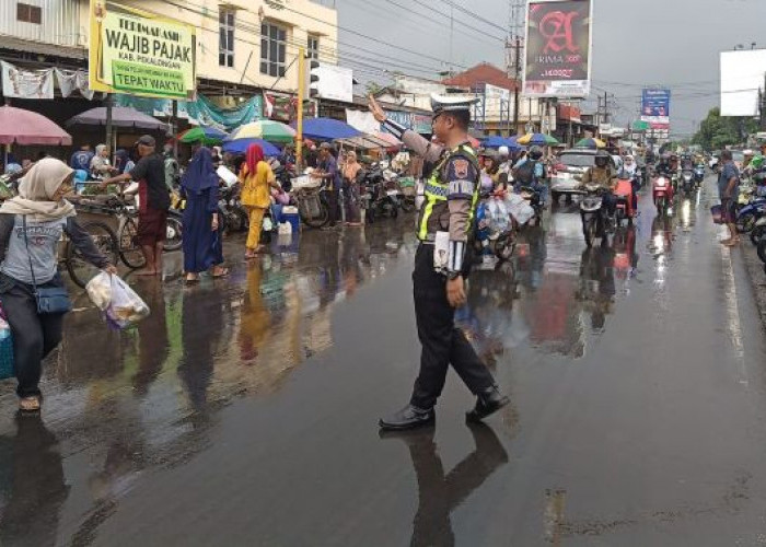 Diguyur Hujan Deras, Personel Polres Pekalongan Tetap Atur Lalu Lintas di Pagi Hari